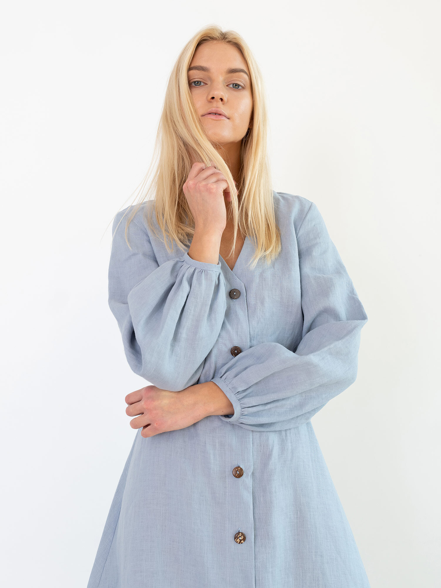 Close view of the DIA Bluestone linen dress with V neckline and coconut shell buttons