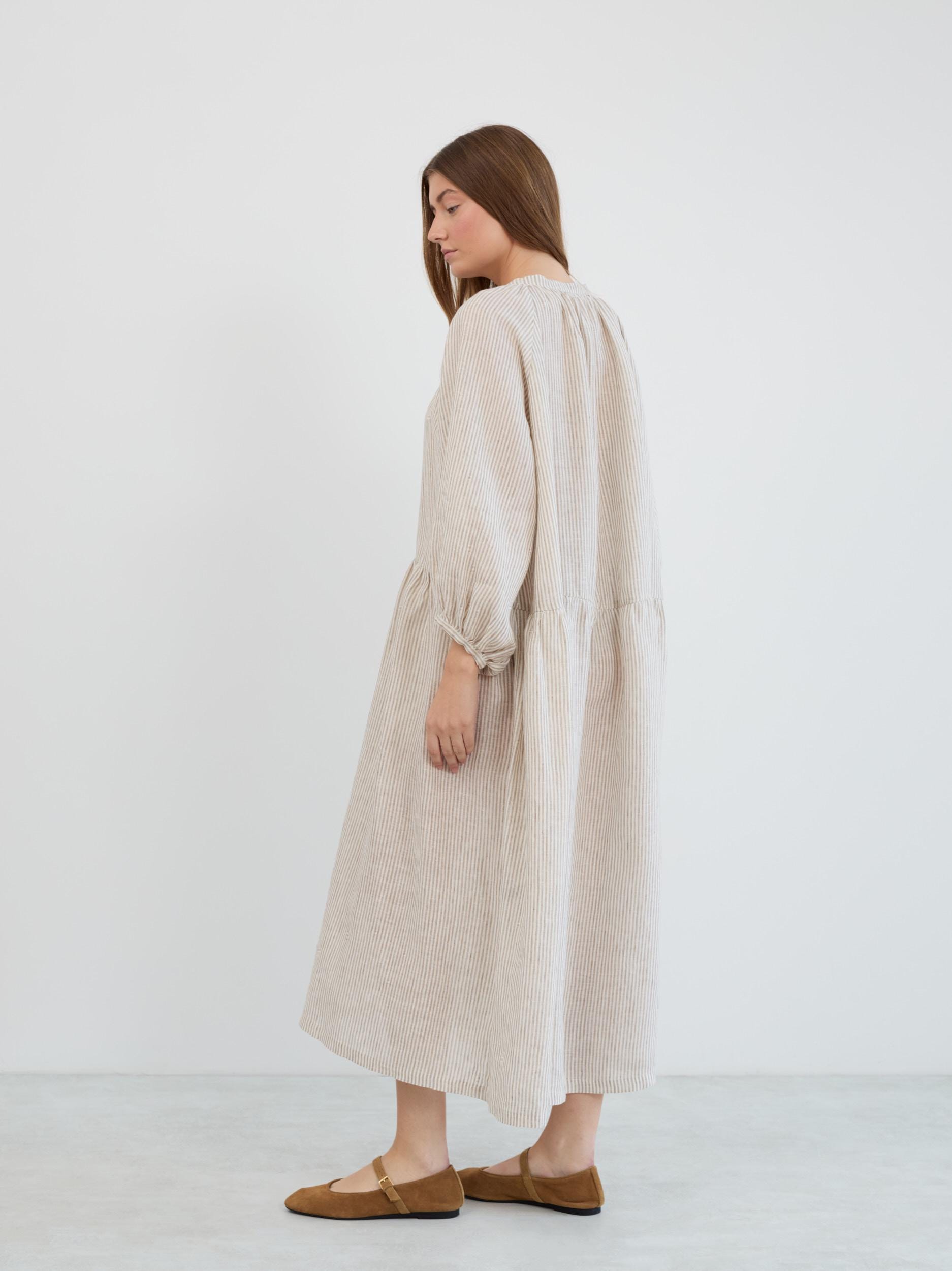 Side-back view of the Etta striped linen maxi dress showing the full-length flowing silhouette, dropped waist gather, and 3/4 balloon sleeves