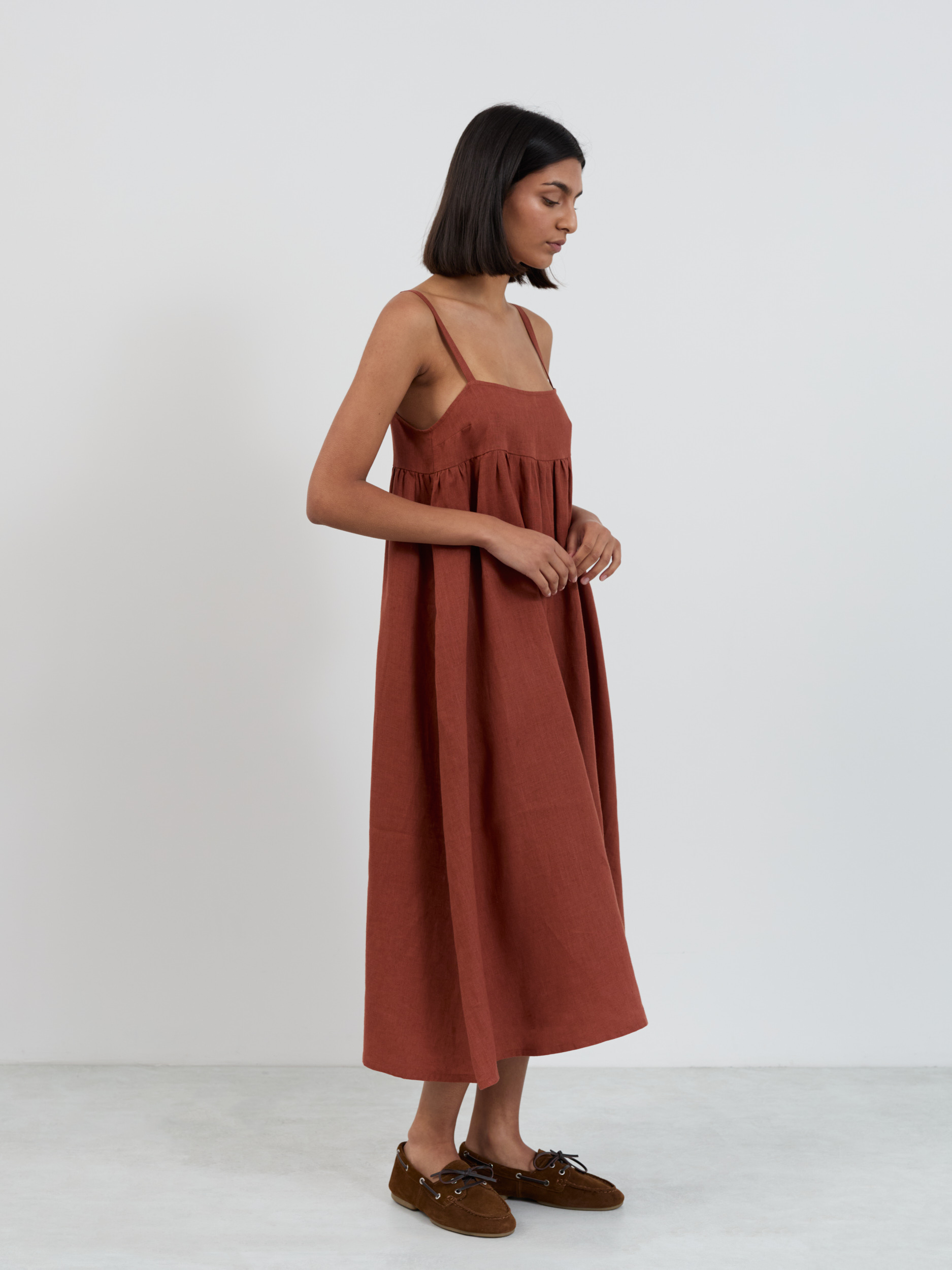 Side profile of linen midi sundress showing voluminous gathered skirt from empire waist