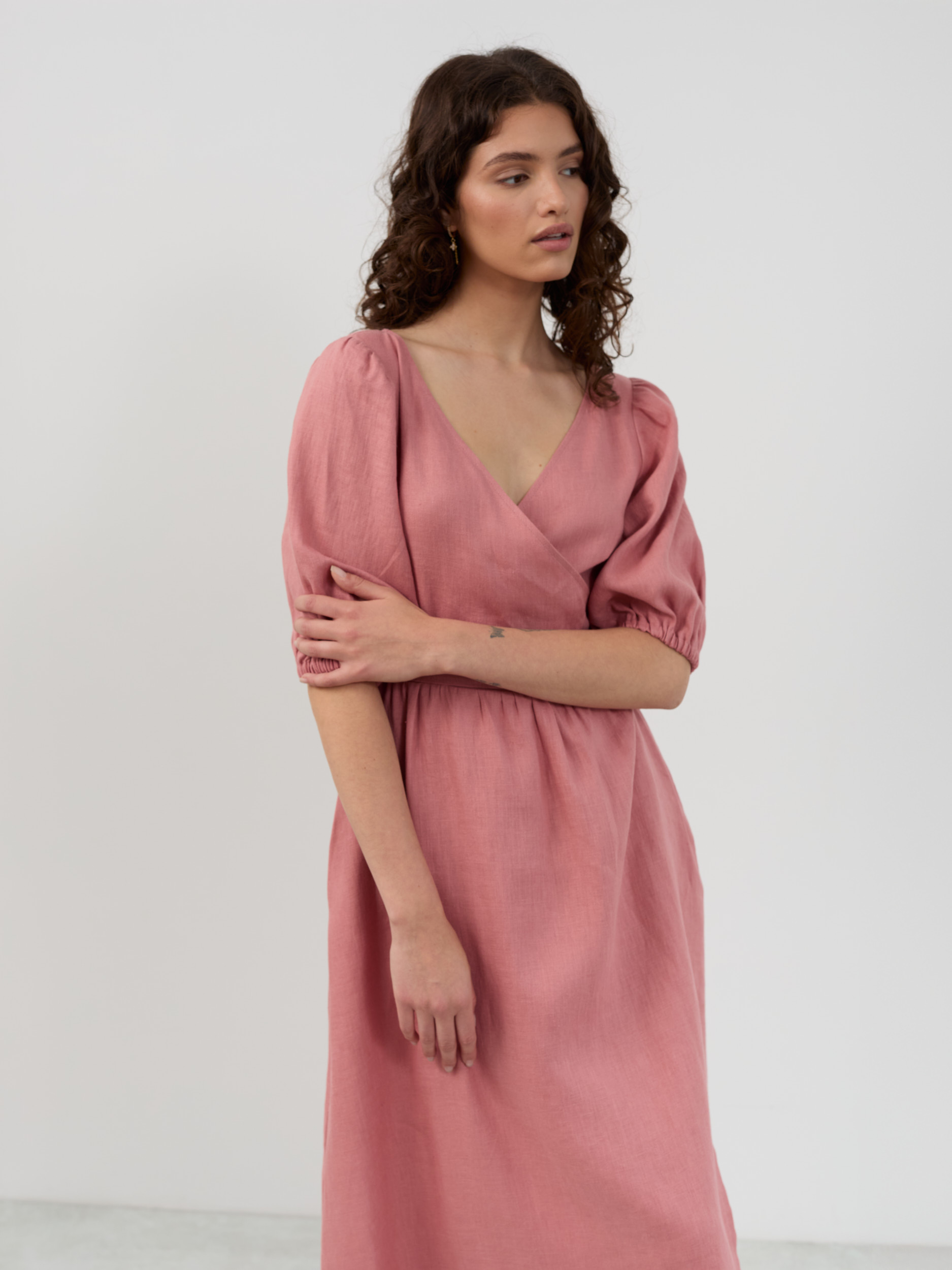 Upper body detail of salmon pink linen dress with puff sleeves, elasticized cuffs and wrap neckline
